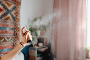 woman using room spray in her flat smell amazing